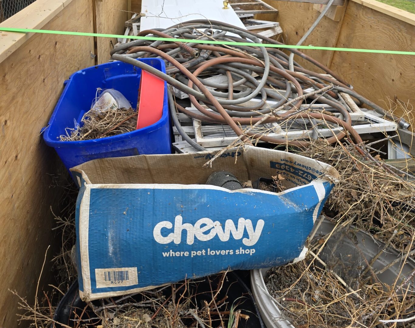 Trailer loaded with outdoor junk like chicken coop, hoses, and cans for residential junk removal in Park County, WY—Good Junk Removal.